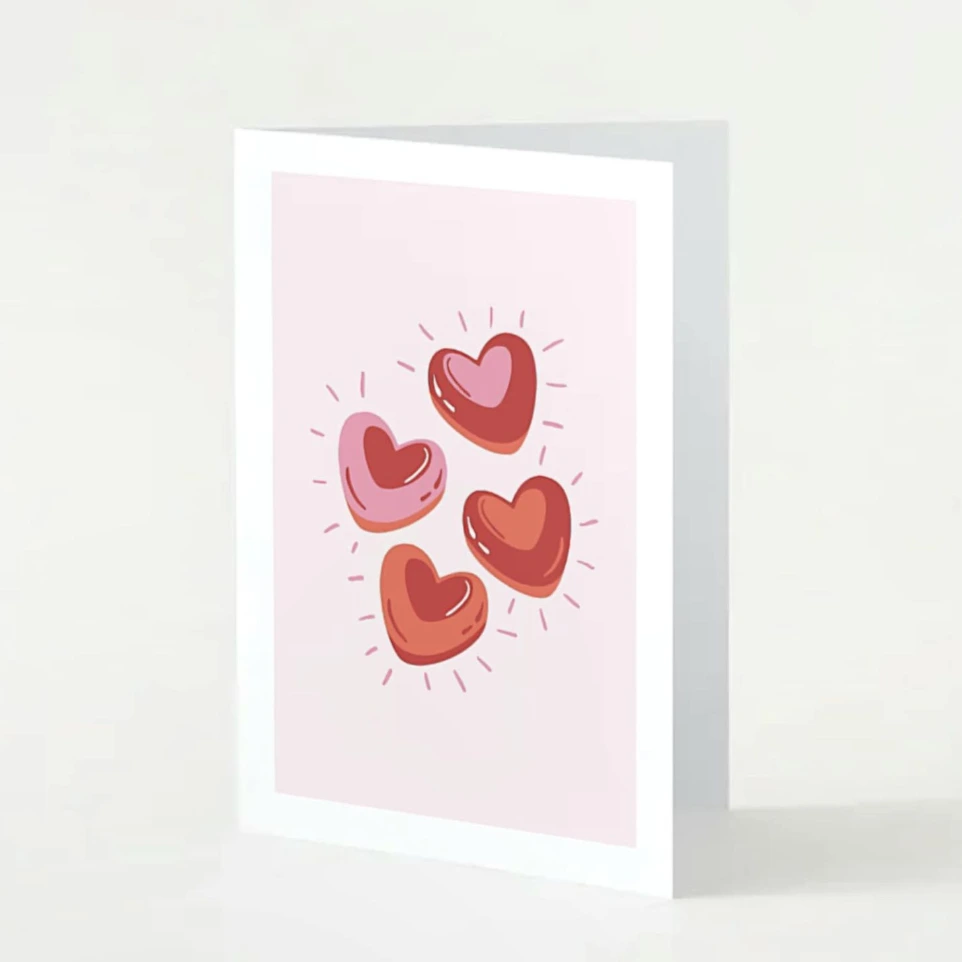 Carte St.Valentin aux nuances de roses avec des cœurs rouges.