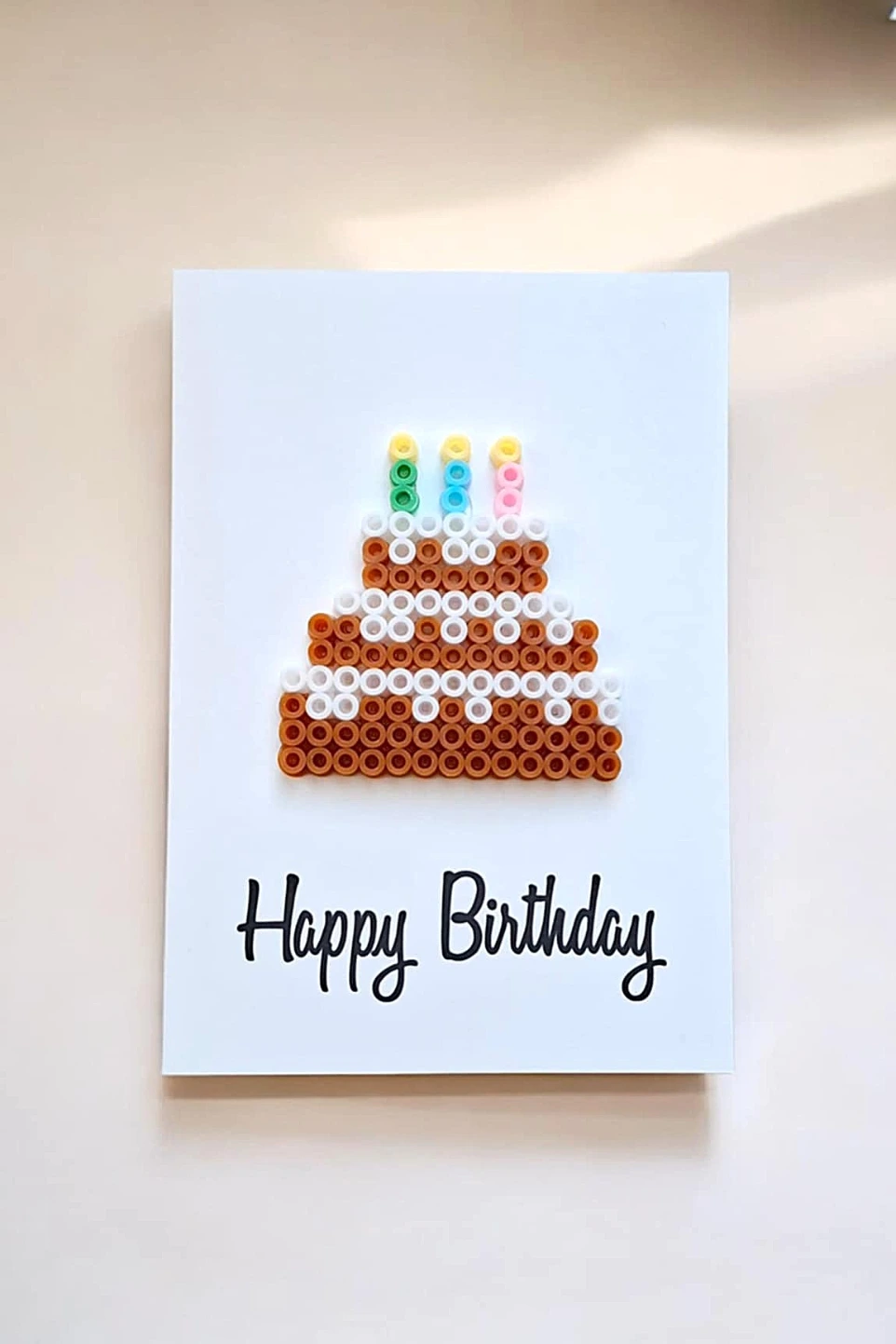 Cette carte est ornée d'un magnifique gâteau avec des perles à repasser qui donne un effet 3D captivant.